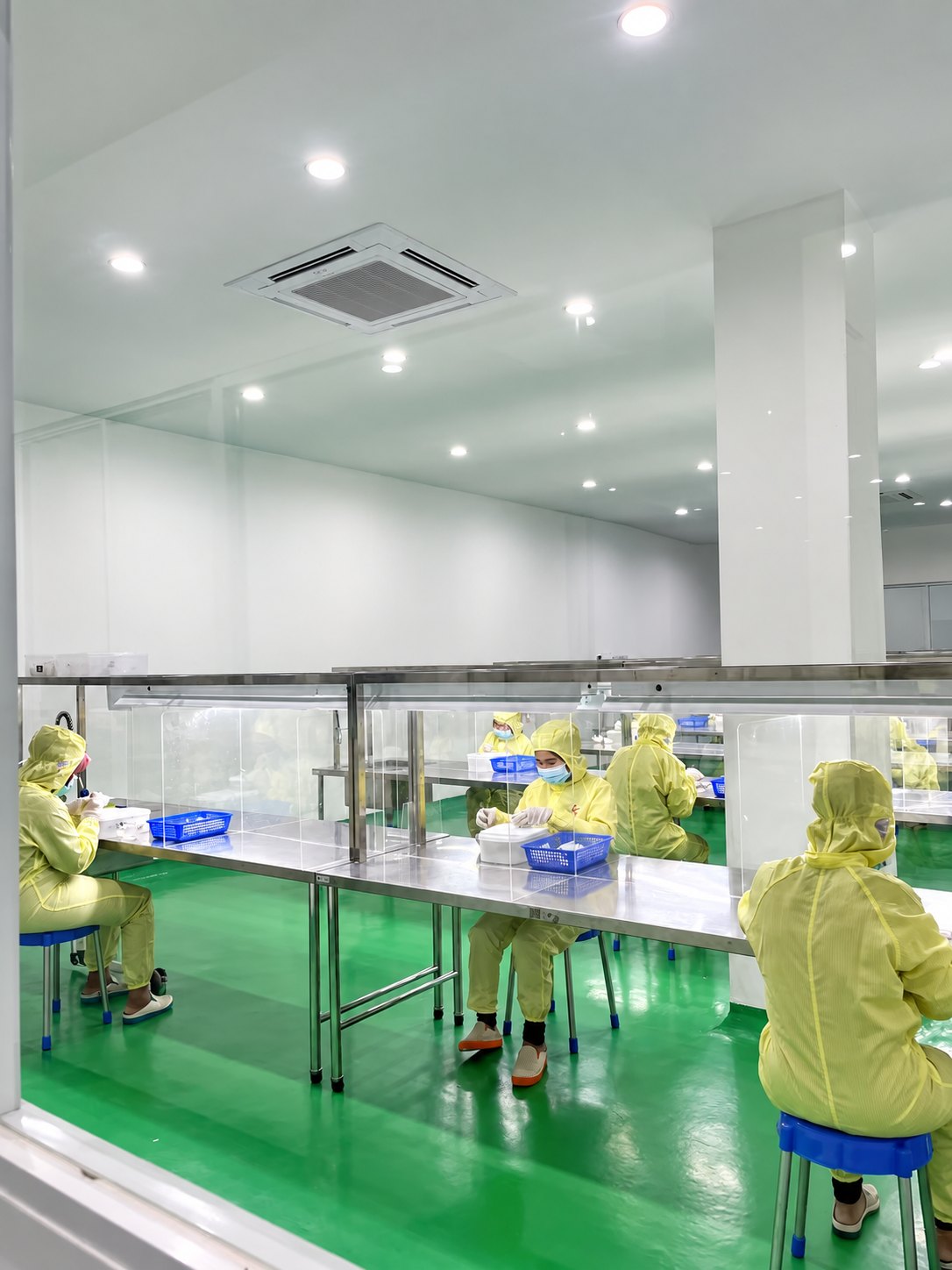 Workers at individual processing stations in an edible bird's nest facility