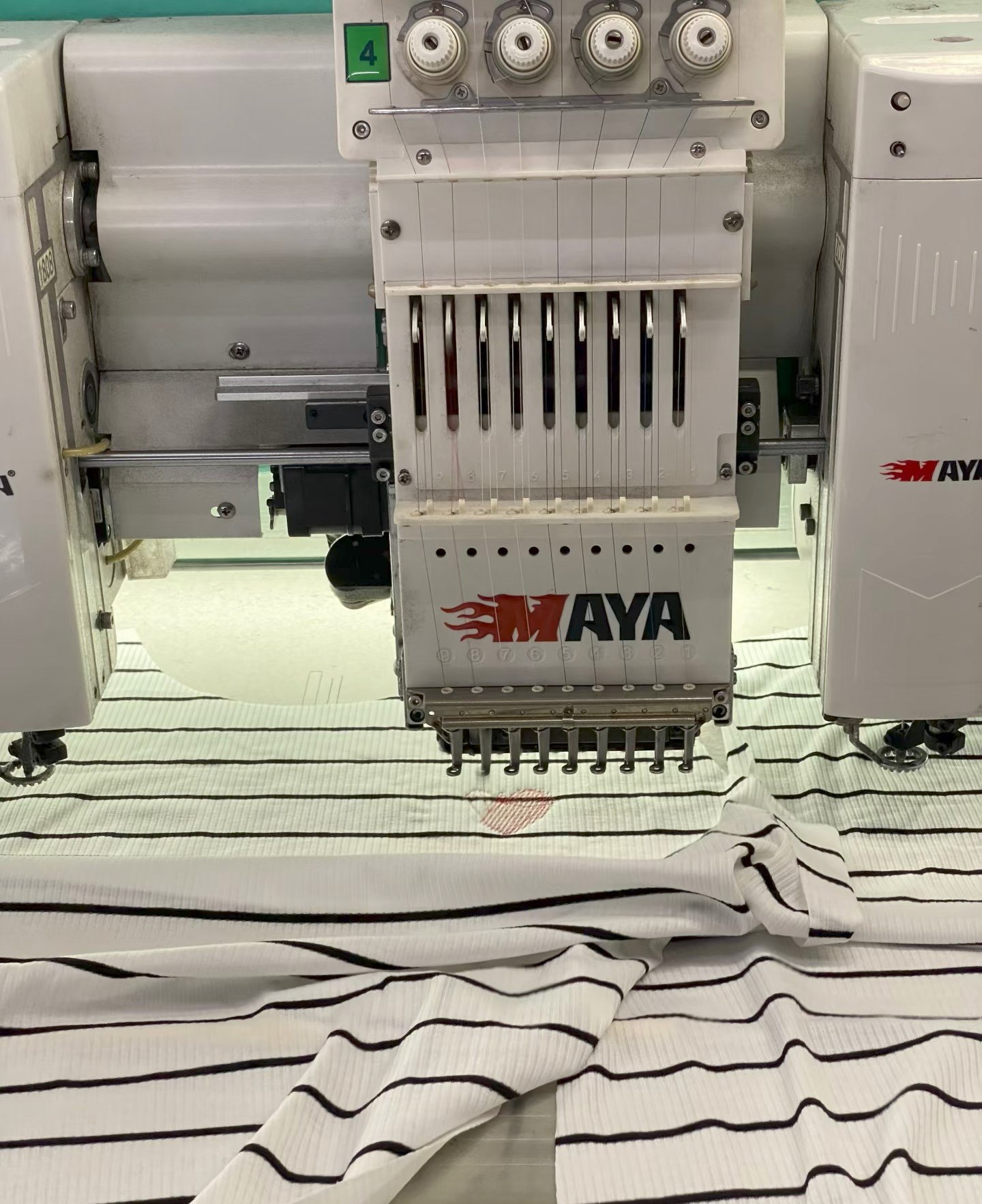 Industrial embroidery machine stitching a garment panel